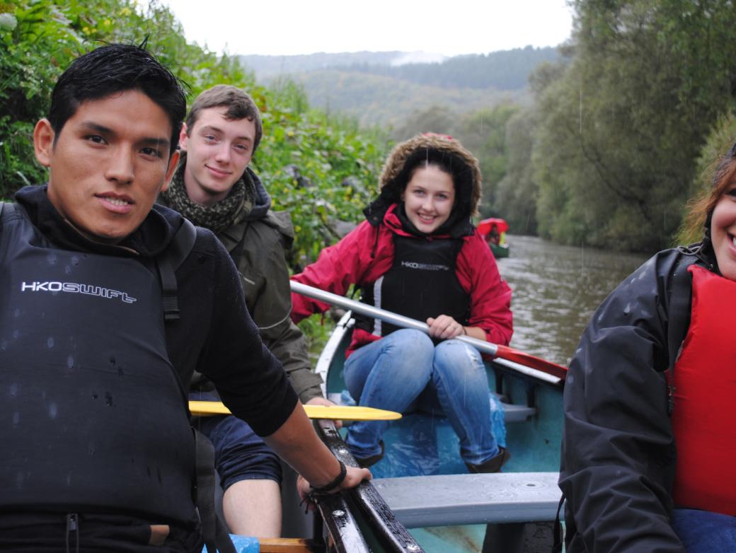 Das Bild zeigt junge Menschen beim Paddeln auf einem Boot