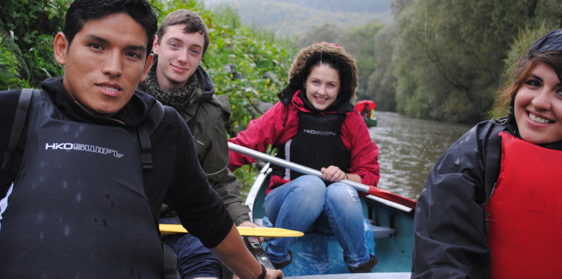 Das Bild zeigt junge Menschen beim Paddeln auf einem Boot