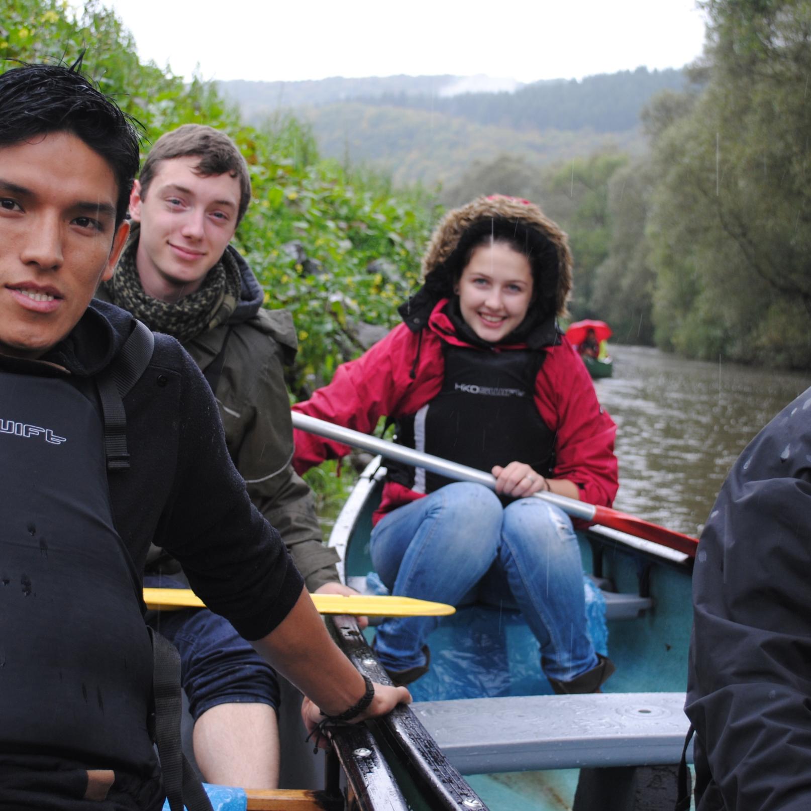 Das Bild zeigt junge Menschen beim Paddeln auf einem Boot