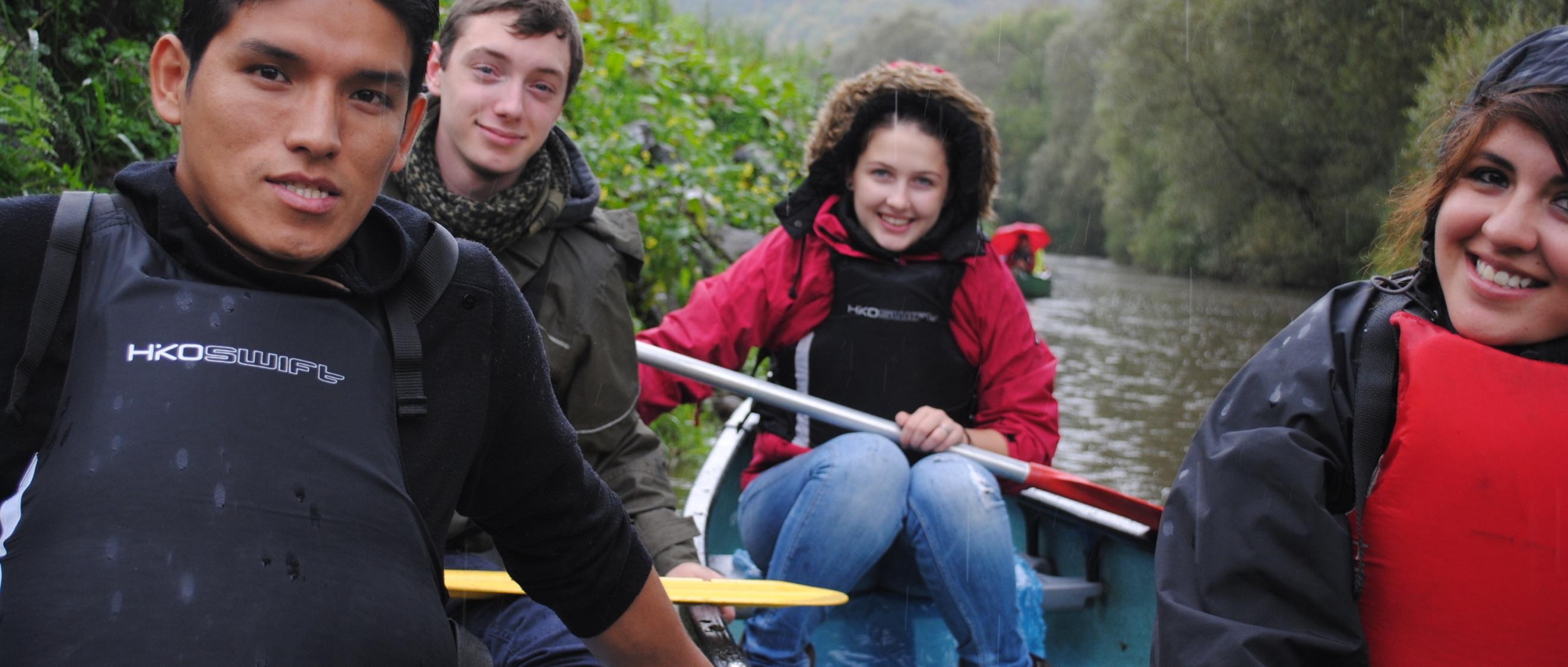 Das Bild zeigt junge Menschen beim Paddeln auf einem Boot
