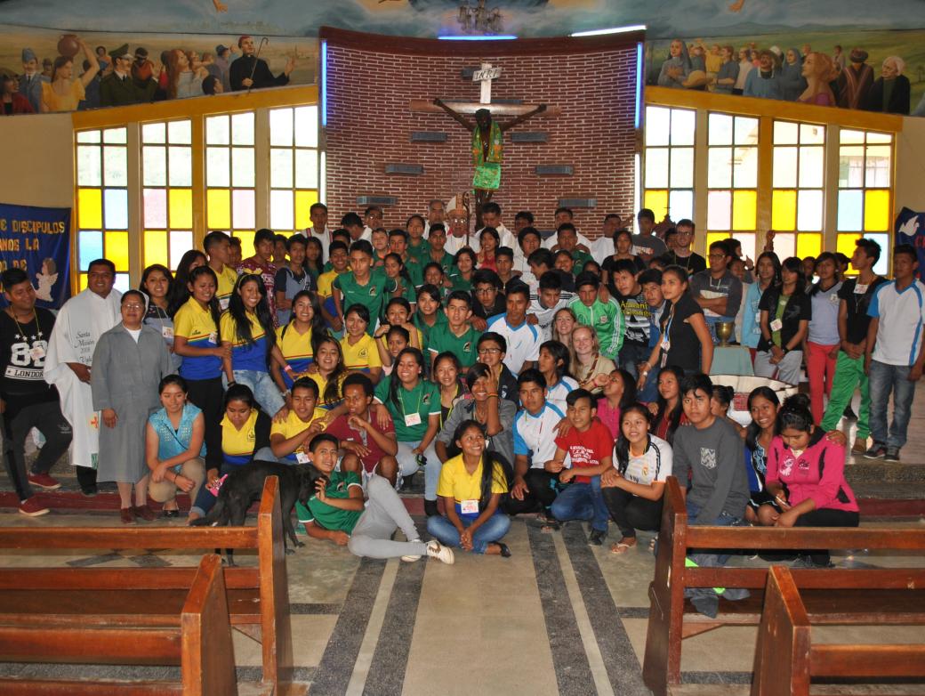 Das Bild zeigt eine Kirche in Bolivien, darauf ist eine große Gruppe von Personen vorm Altar