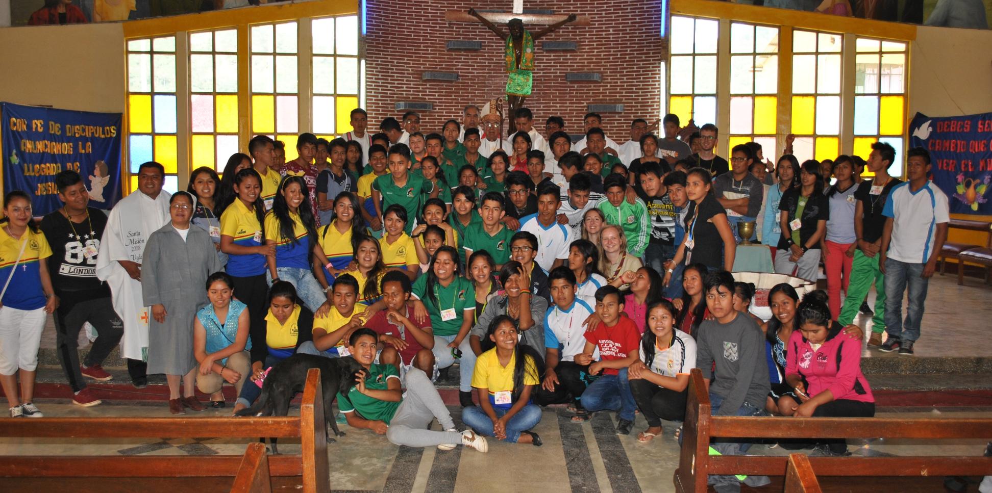 Das Bild zeigt eine Kirche in Bolivien, darauf ist eine große Gruppe von Personen vorm Altar