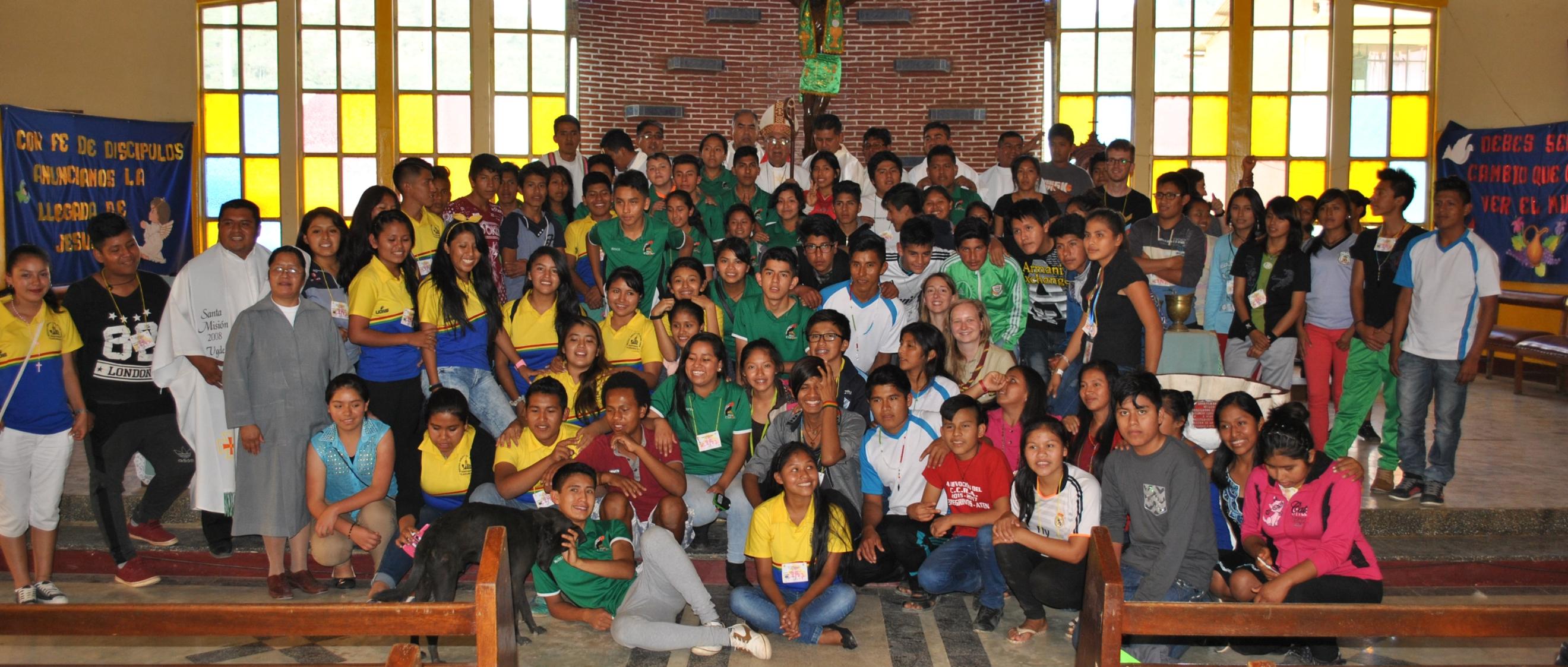Das Bild zeigt eine Kirche in Bolivien, darauf ist eine große Gruppe von Personen vorm Altar