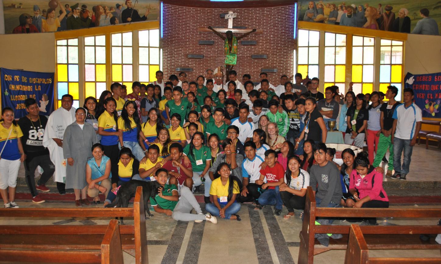Das Bild zeigt eine Kirche in Bolivien, darauf ist eine große Gruppe von Personen vorm Altar