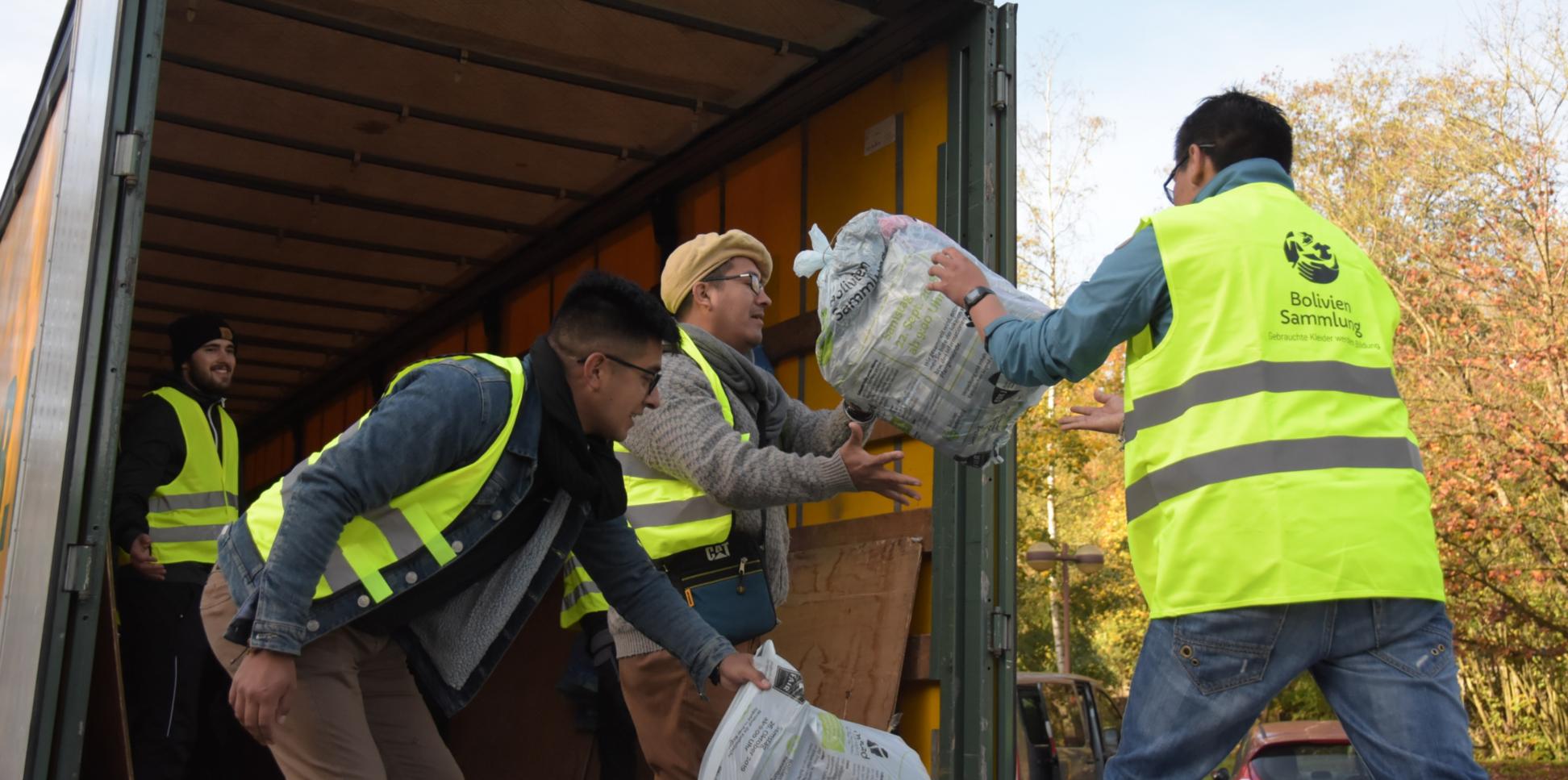 Das Bild zeigt Jugendliche beim Einladen von Kleidersäcken in einen LKW