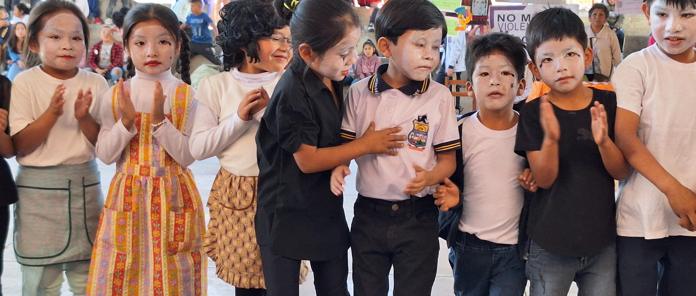 Das Bild zeigt Kinder. Ihre Gesichter sind weiß geschminkt.