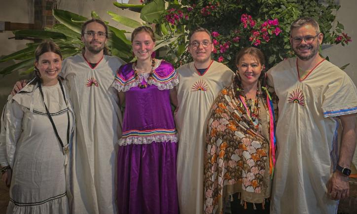 Das Bild zeigt sechs Menschen. Sie sind auf Begegnungsreise in Bolivien und tragen traditionelle Kleidung.