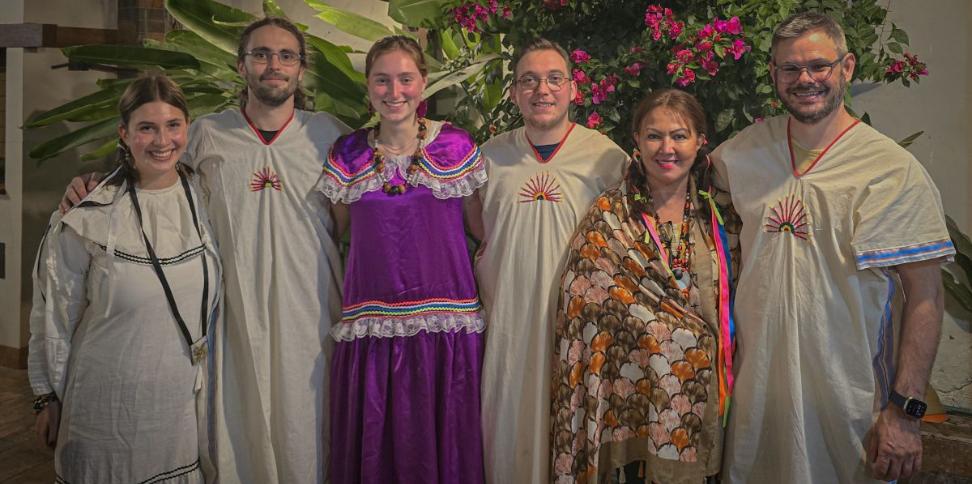 Das Bild zeigt sechs Menschen. Sie sind auf Begegnungsreise in Bolivien und tragen traditionelle Kleidung.