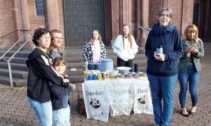 Das Bild zeigt die Ausgabe von Speisen an Helfende vor einer Kirche