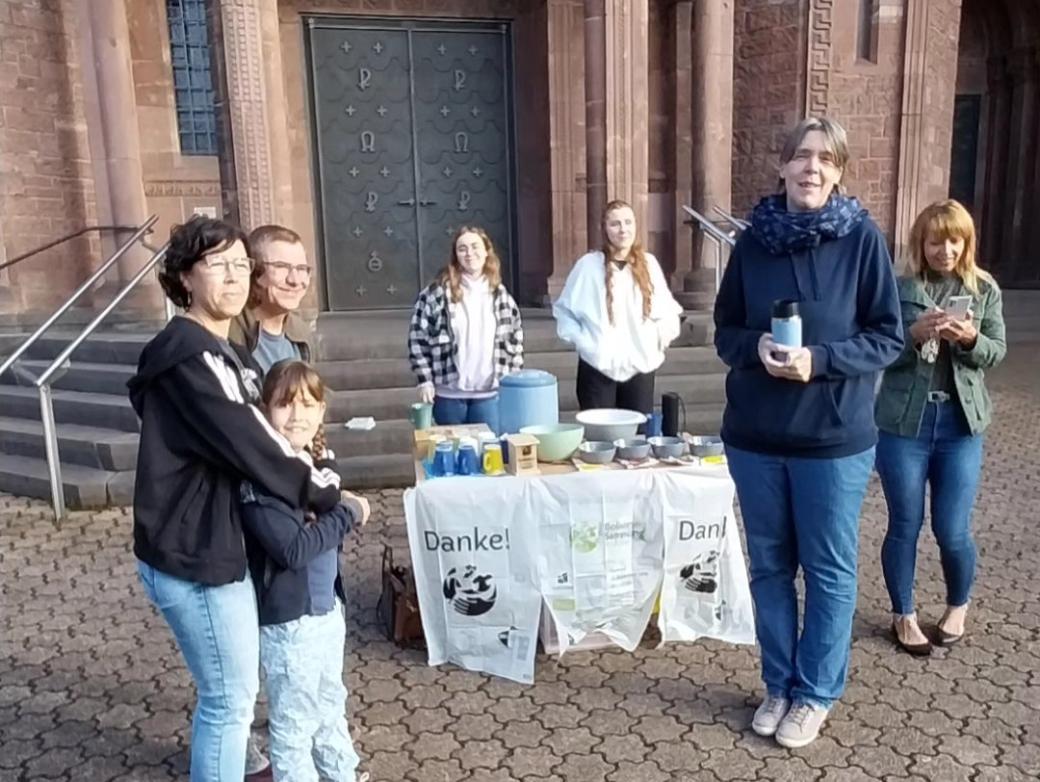 Das Bild zeigt die Ausgabe von Speisen an Helfende vor einer Kirche