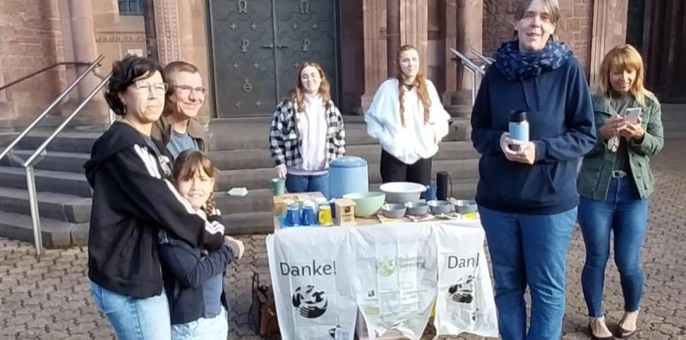 Das Bild zeigt die Ausgabe von Speisen an Helfende vor einer Kirche