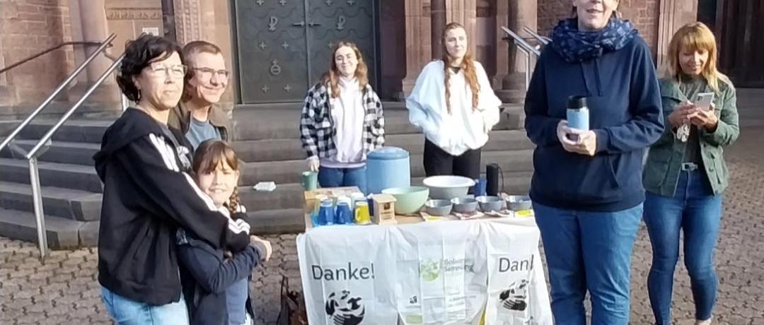 Das Bild zeigt die Ausgabe von Speisen an Helfende vor einer Kirche
