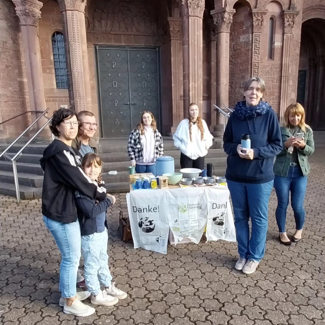 Das Bild zeigt die Ausgabe von Speisen an Helfende vor einer Kirche