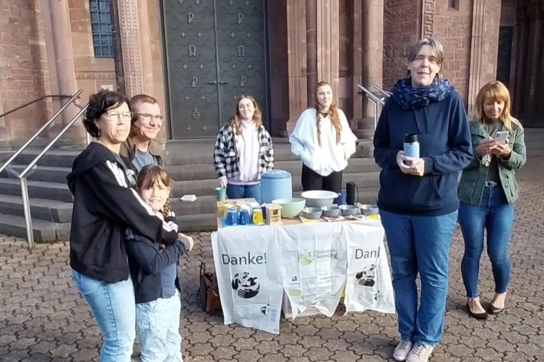Das Bild zeigt die Ausgabe von Speisen an Helfende vor einer Kirche