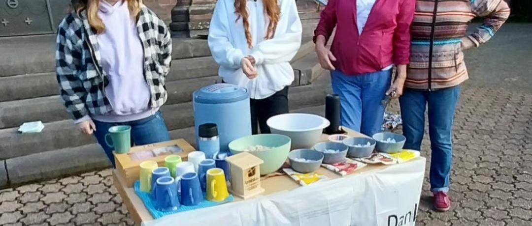 Das Bild zeigt vier weibliche Personen (jung und alt) welche Speisen für Helfende bei einer Kleidersammlung anbieten