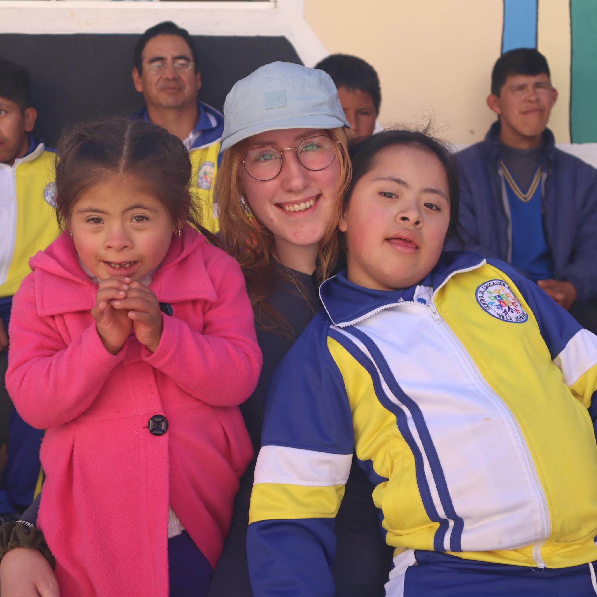 Das Bild zeigt eine junge Dame die zwei Kinder im Arm hält.