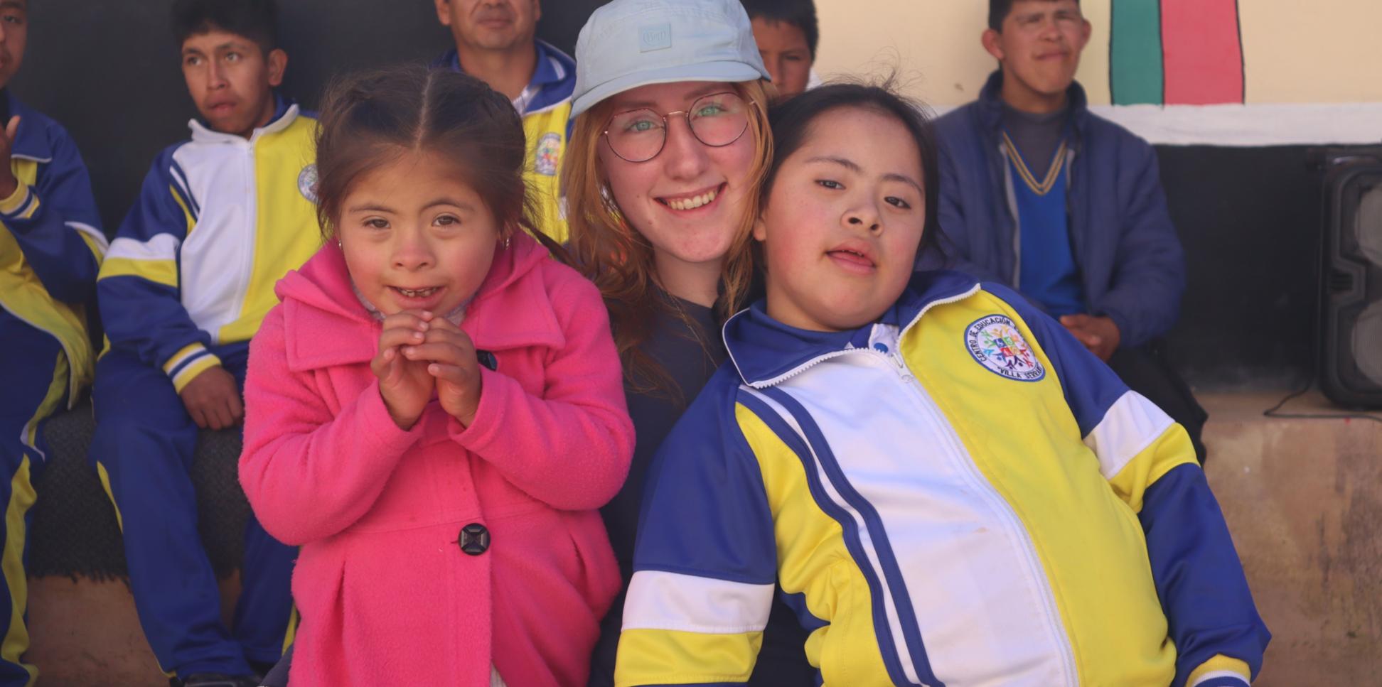 Das Bild zeigt eine junge Dame die zwei Kinder im Arm hält.