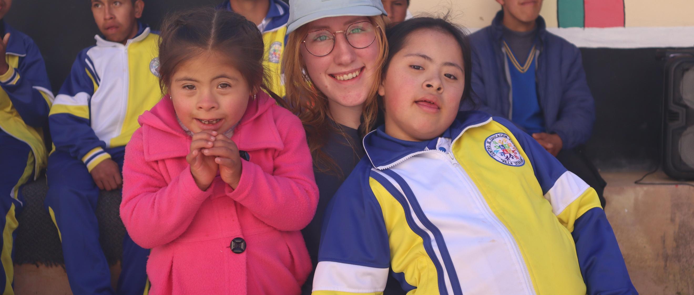 Das Bild zeigt eine junge Dame die zwei Kinder im Arm hält.