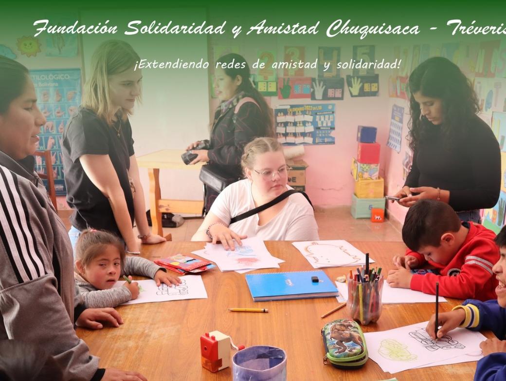 Das Bild zeigt einen Blick in eine Schulklasse in Bolivien. Eine Gruppe von Kindern lernt an Tischen.