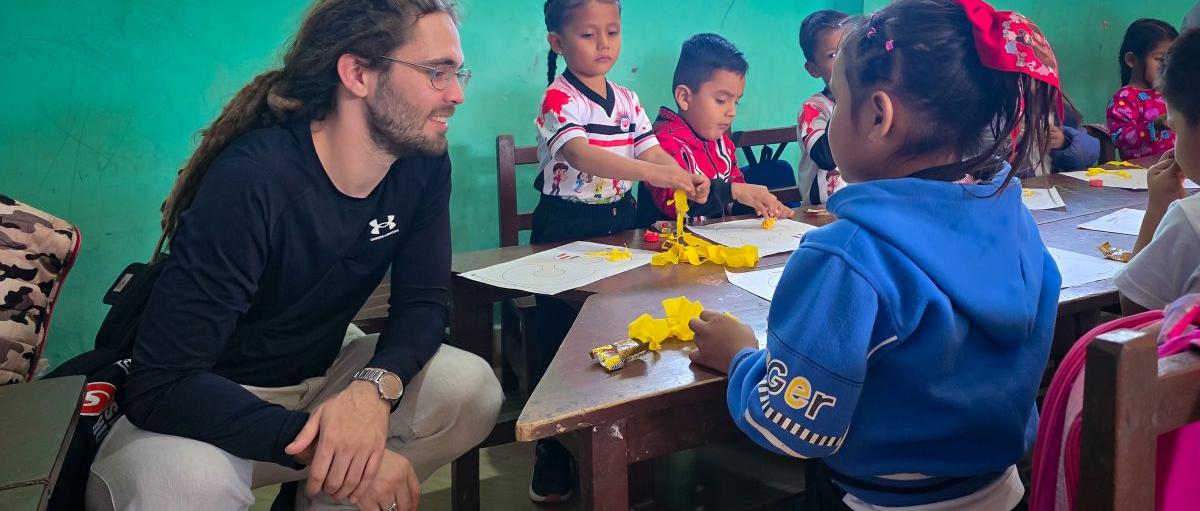 Das Bild zeigt einen Blick in eine Schulklasse in Bolivien. Kinder lernen an einem Tisch.