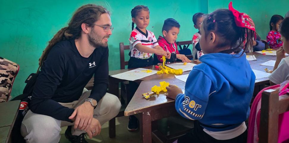 Das Bild zeigt einen Blick in eine Schulklasse in Bolivien. Kinder lernen an einem Tisch.