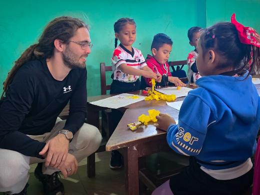 Das Bild zeigt einen Blick in eine Schulklasse in Bolivien. Kinder lernen an einem Tisch.