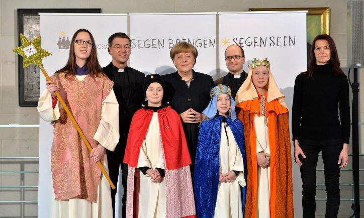 Das Bild zeigt Sternsinger bei Angela Merkel