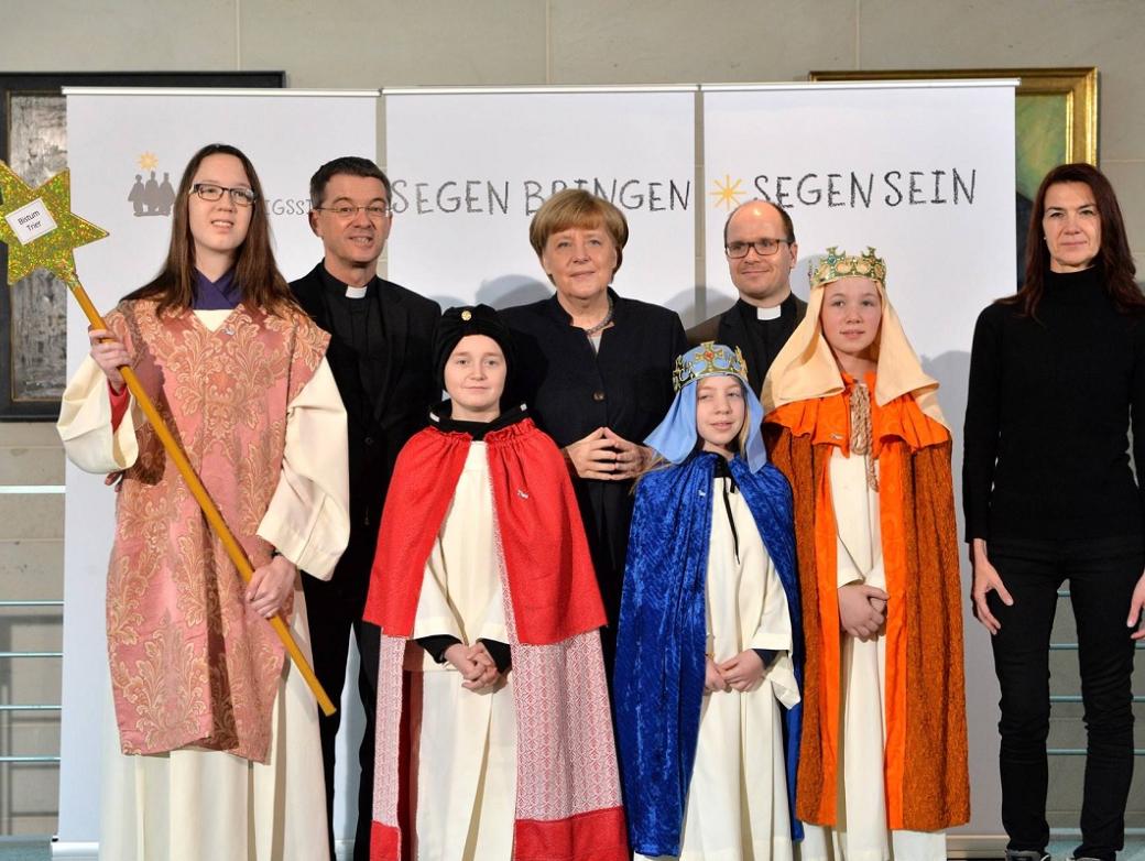 Das Bild zeigt Sternsinger bei Angela Merkel