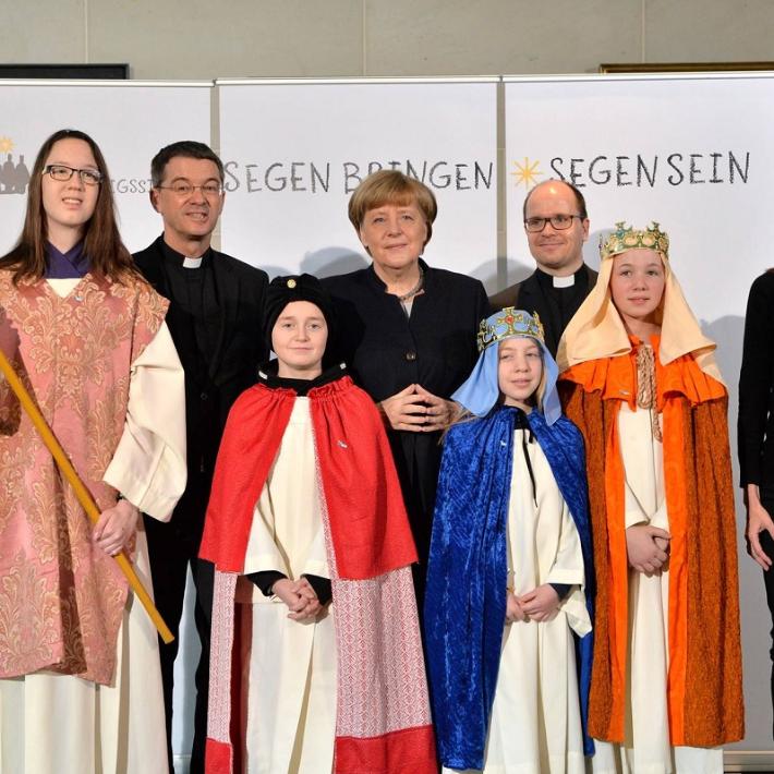 Das Bild zeigt Sternsinger bei Angela Merkel