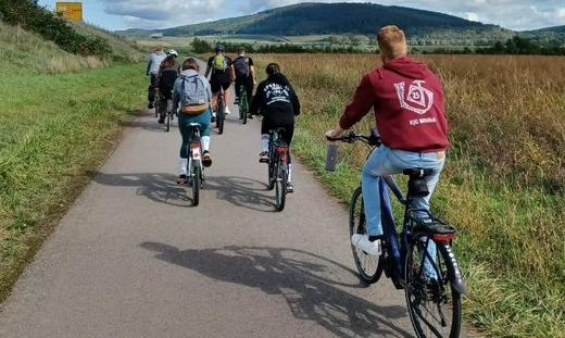 Das Bild zeigt von hinten fotografiert junge Menschen beim Radfahren