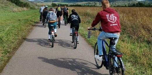 Das Bild zeigt von hinten fotografiert junge Menschen beim Radfahren