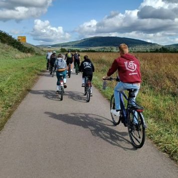 Das Bild zeigt von hinten fotografiert junge Menschen beim Radfahren