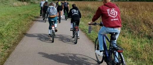 Das Bild zeigt von hinten fotografiert junge Menschen beim Radfahren