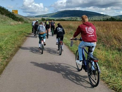 Das Bild zeigt von hinten fotografiert junge Menschen beim Radfahren