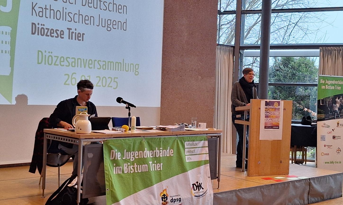 Das Bild zeigt ein Podest mit Rednerpult und Leinwand.