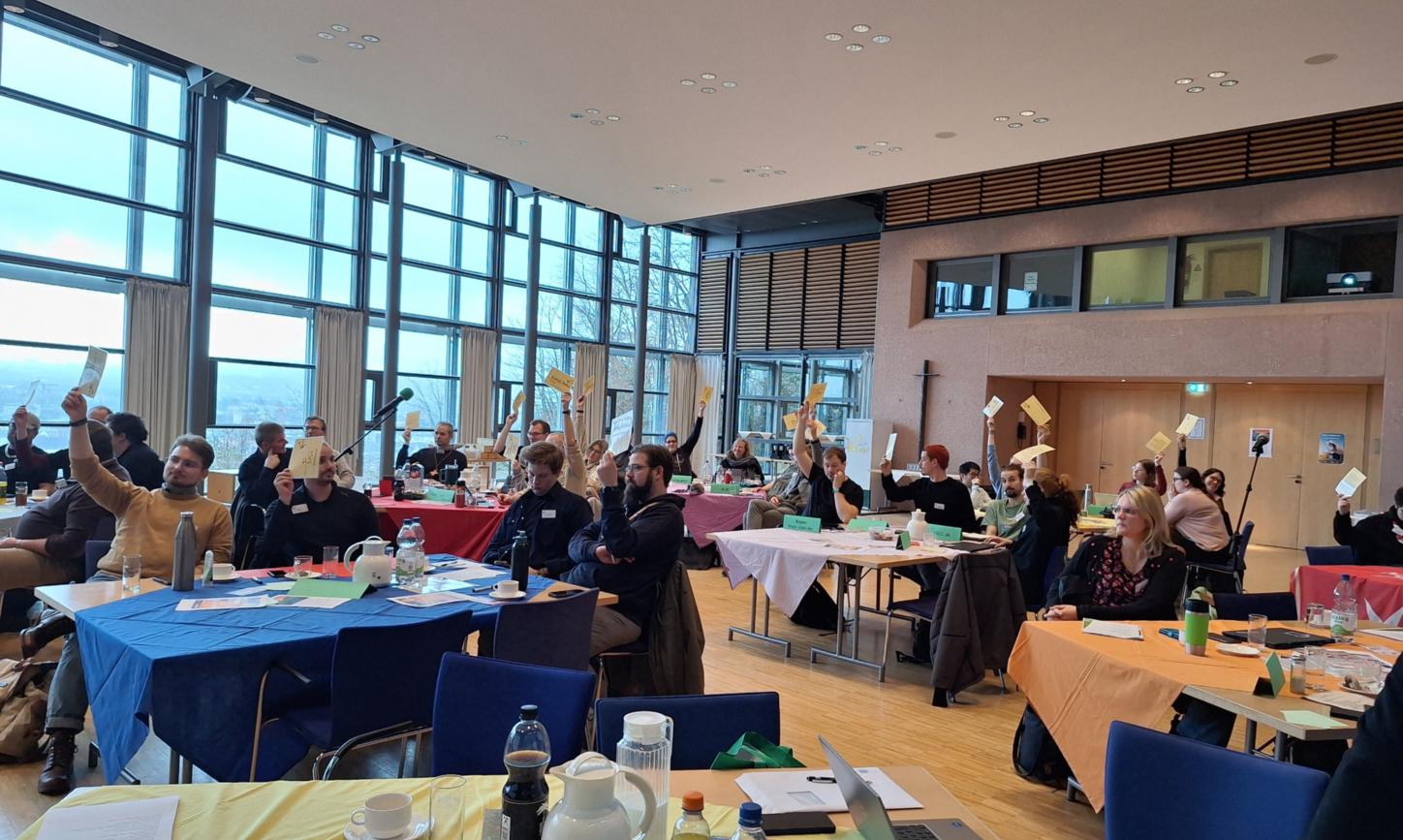 Das Bild zeigt eine Konferenz.