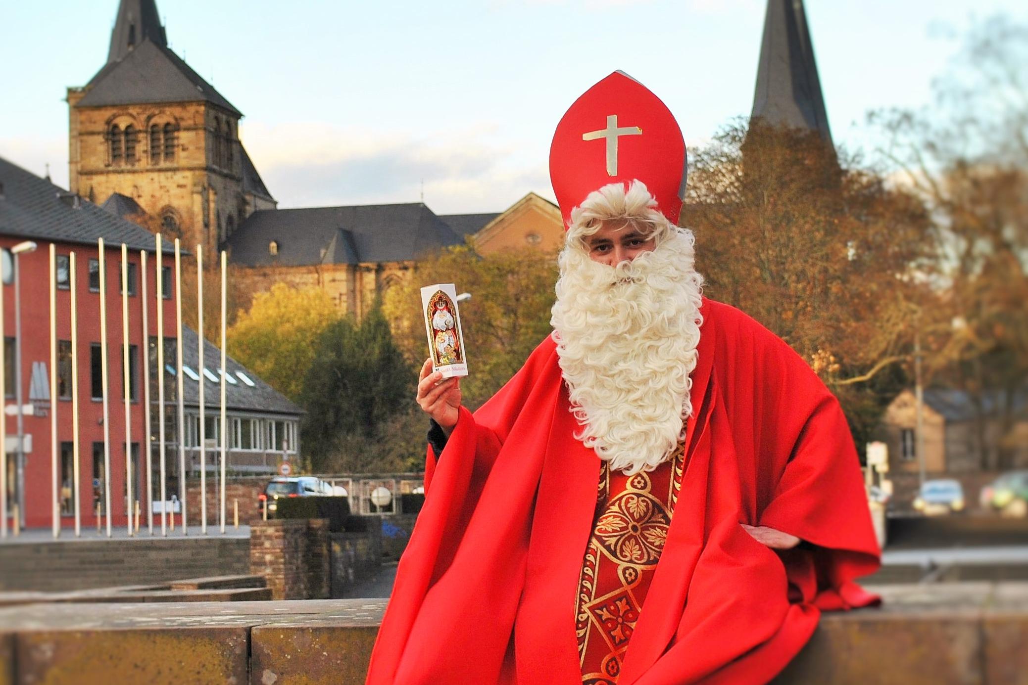 Das Bild zeigt zeigt einen Nikolaus, im Hintergrund ist das bischöfliche Generalvikariat und der Trierer Dom